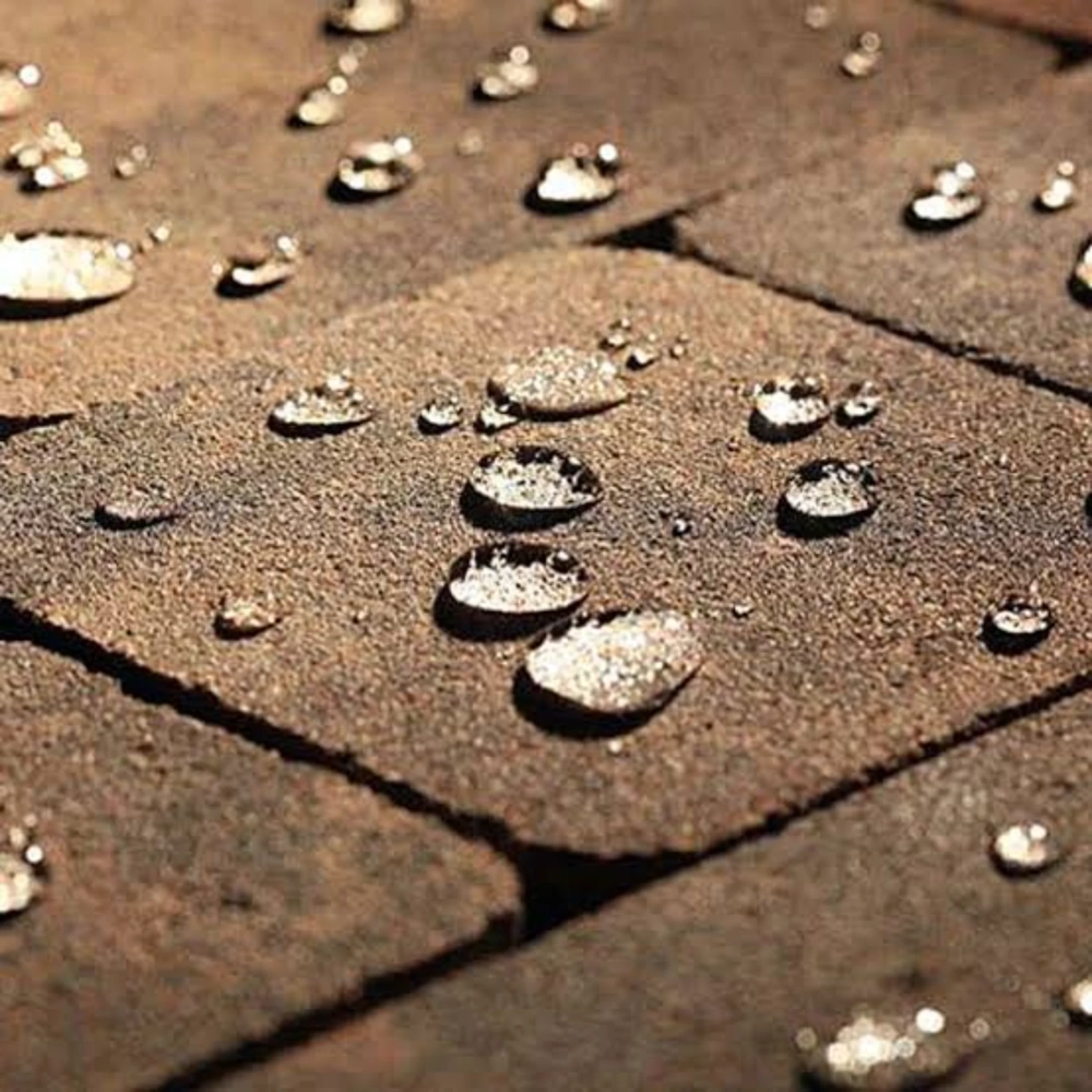 Impregnacja kostki brukowej: krople wody na suchej, oczyszczonej nawierzchni ceglanej